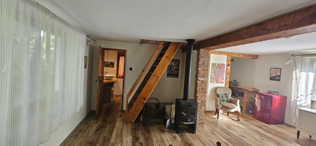 a living room with a wooden floor and a staircase at Domek Basia in Deskurów