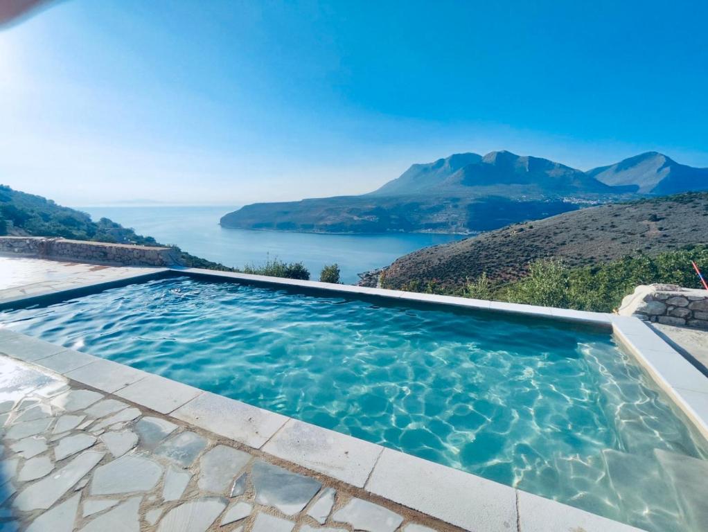 a swimming pool with a view of a body of water at Mani Spot Sunset View in Areopoli