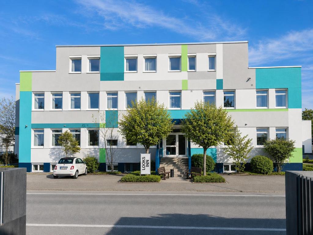 a building with a car parked in front of it at looks-inn in Viernheim