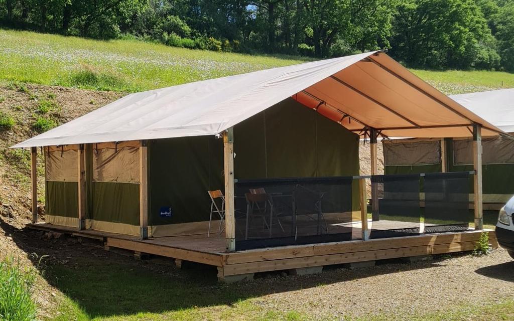 a large tent with a deck in a field at Bungalow Kotaventure in Le Mesnil-Villement