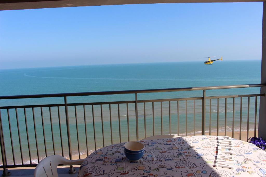 a table on a balcony with a view of the beach at Apartamentos Guillem in Playa de Miramar