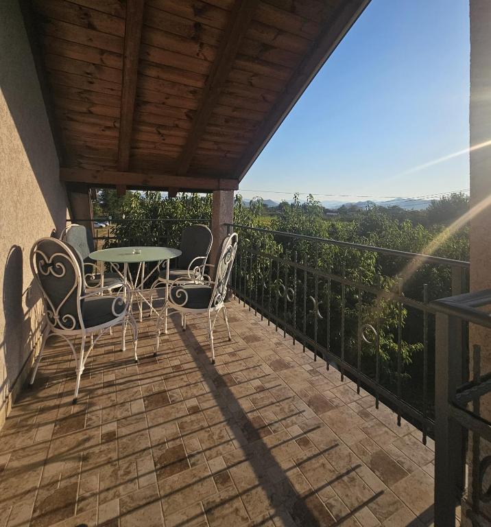 a patio with a table and chairs on a balcony at MontSky Apartment - Podgorica Airport in Mitrovići