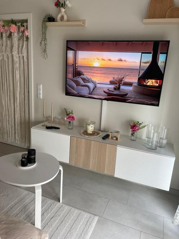 a living room with a flat screen tv on a wall at studio siesta in Pétange