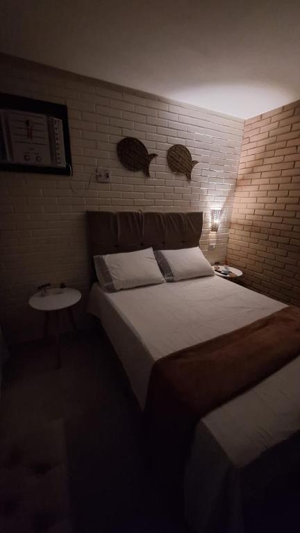 a bedroom with a large bed and a sink at Kitnet Tijolo Ecológico 02 in Tamandaré