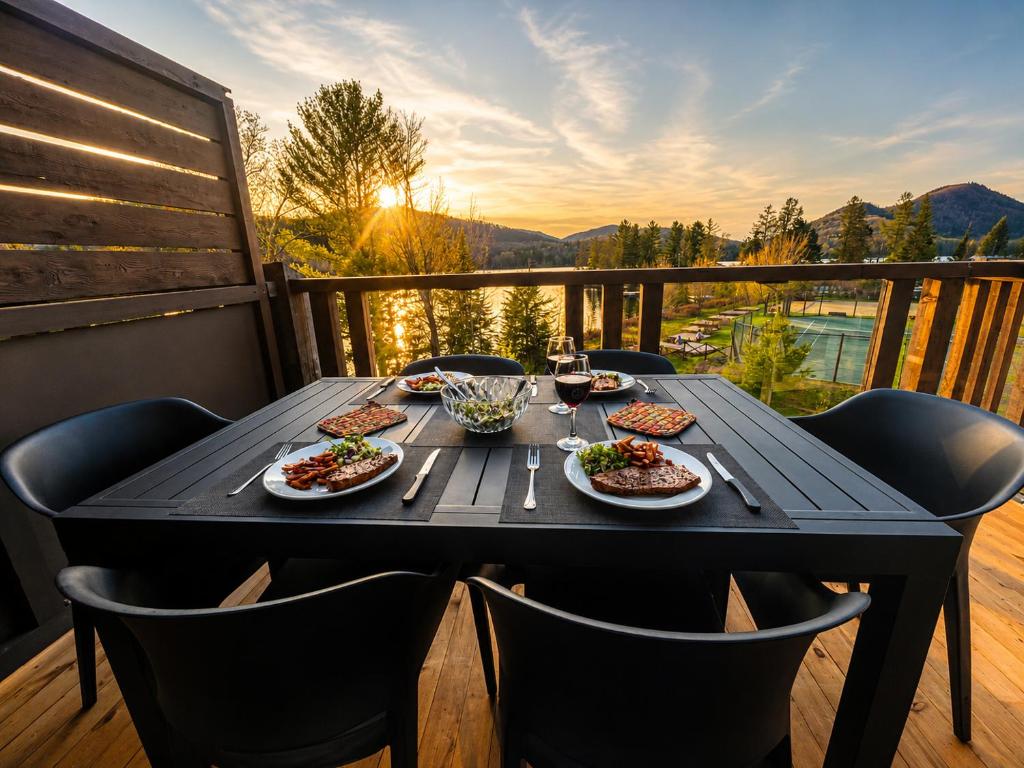 a table with plates of food on a balcony at Appartement-Condo sur Lac Superieur-Mont-Tremblant in Lac-Superieur