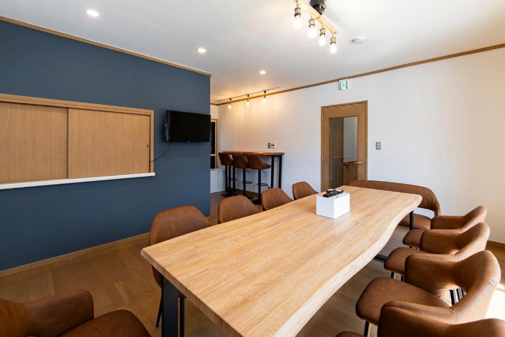 a conference room with a large wooden table and chairs at Guest House Masaru ゲストハウス勝 in Nagano