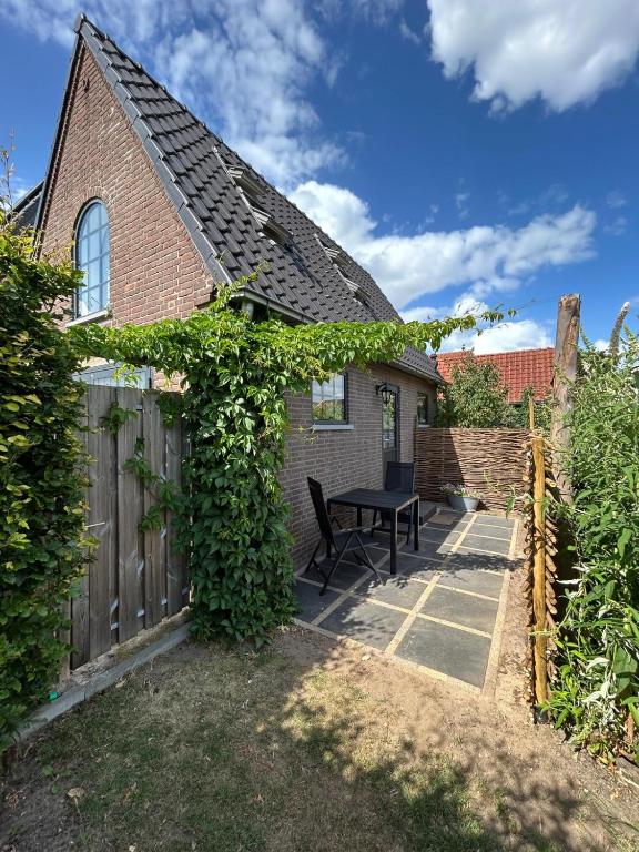 een huis met een picknicktafel in de tuin bij Luxe Tiny House Ooij in Ooij