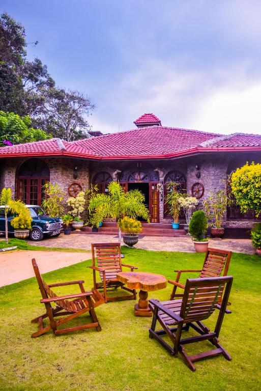 a group of chairs and a table in front of a house at MF Holiday Bungalow in Bandarawela