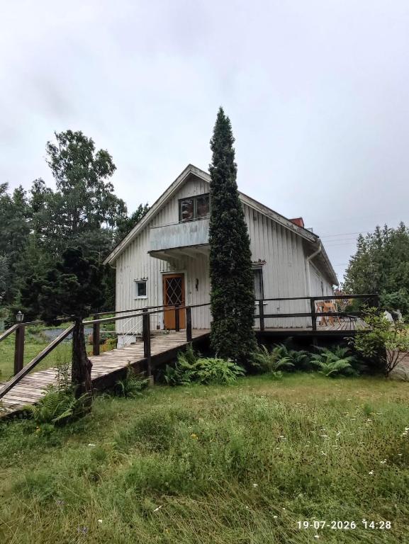a large white barn with a wooden porch at Valiant B&B in Otterbäcken