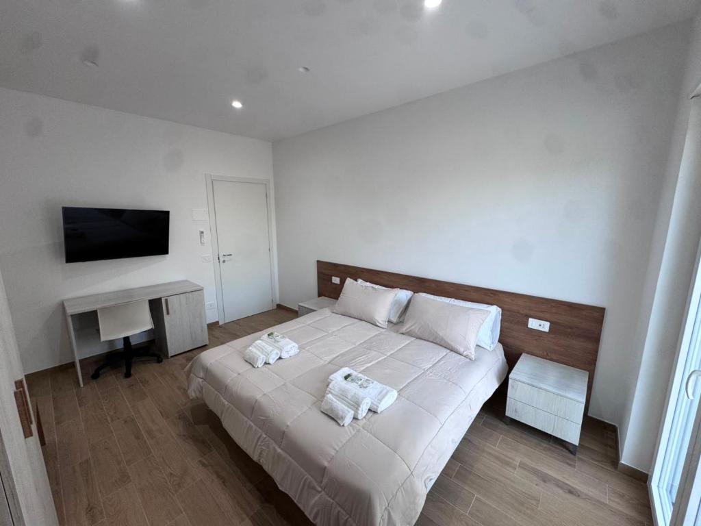 a bedroom with a bed and a desk and a television at Les chambres de Nancy in Contursi Terme