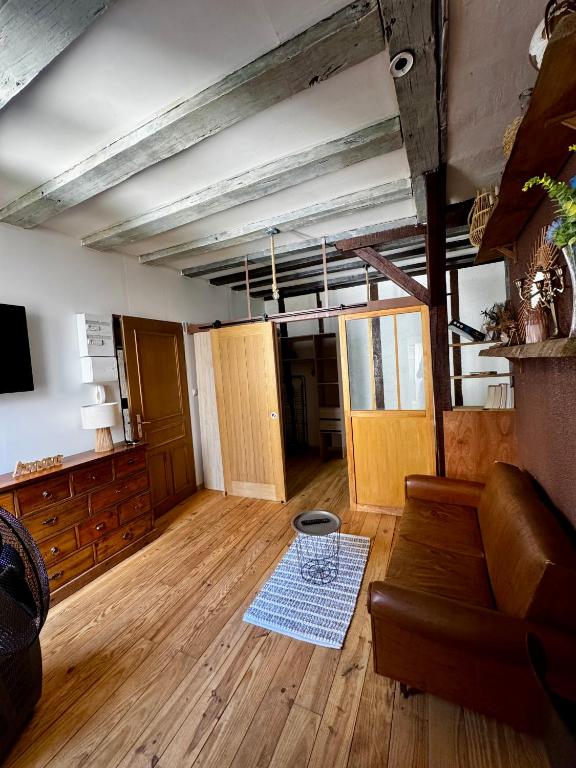 a living room with a couch and wooden floors at T2 L'Atypique au pied de la cathédrale in Bourges