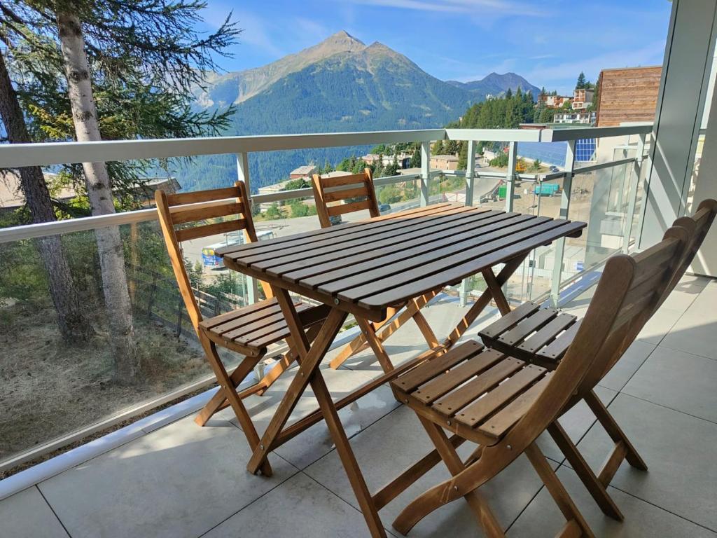 a wooden table and two chairs on a balcony at Evasion in Orcières