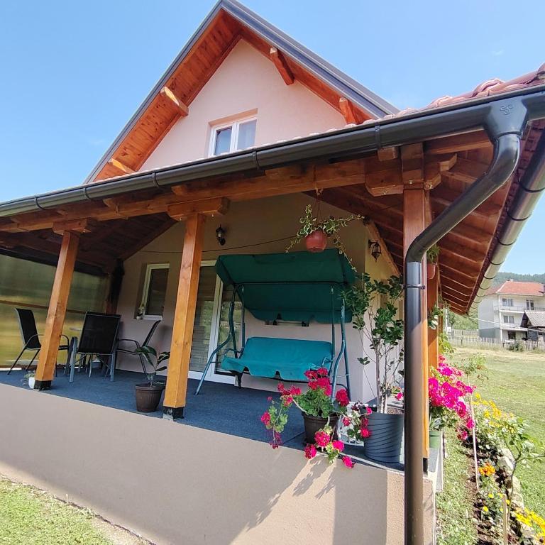 a covered porch of a house with a bench at Kuca za Odmor ISKRA in Mokra Gora