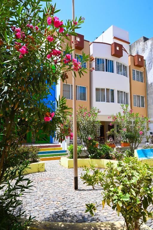 a building with pink flowers in front of it at Hotel Rocha in Ribeira Grande