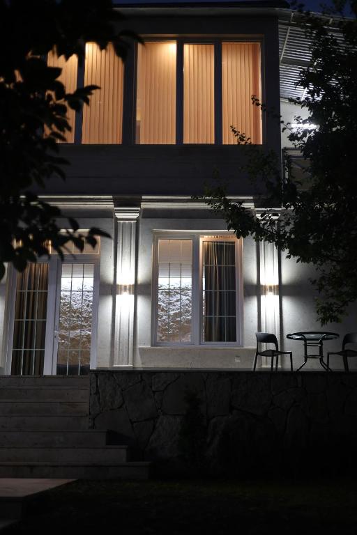 a house with two chairs and a table in front of it at Sunny Home in Gandzakʼar