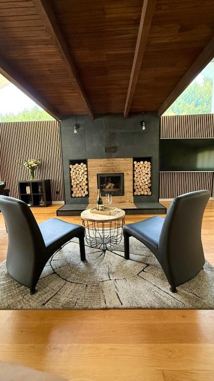 a living room with two chairs and a table at Villa Romeo in Oviedo