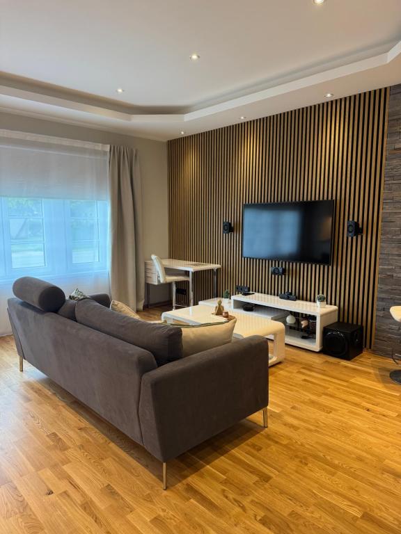 a living room with a couch and a flat screen tv at Maramaa Backyard Bliss in Viljandi