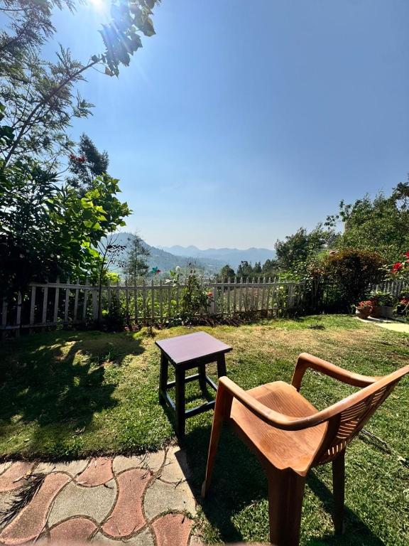 a table and a chair sitting in a yard at Candy Ville Resorts in Coonoor