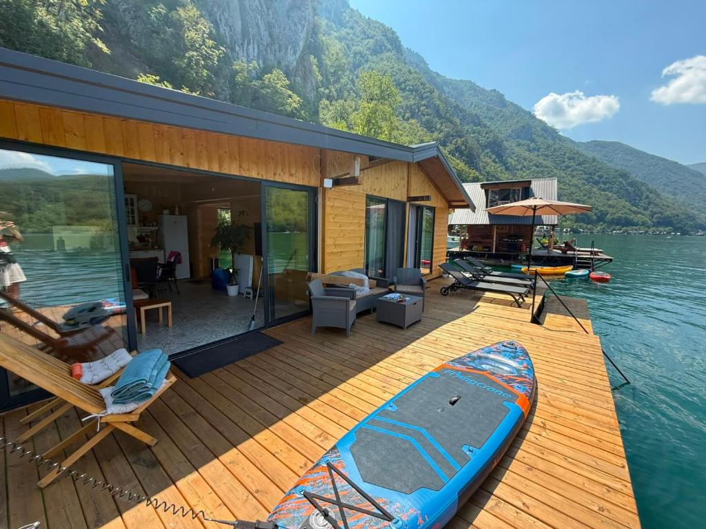 a house on the water with a kayak on the deck at Splav Astra Perućac in Perućac