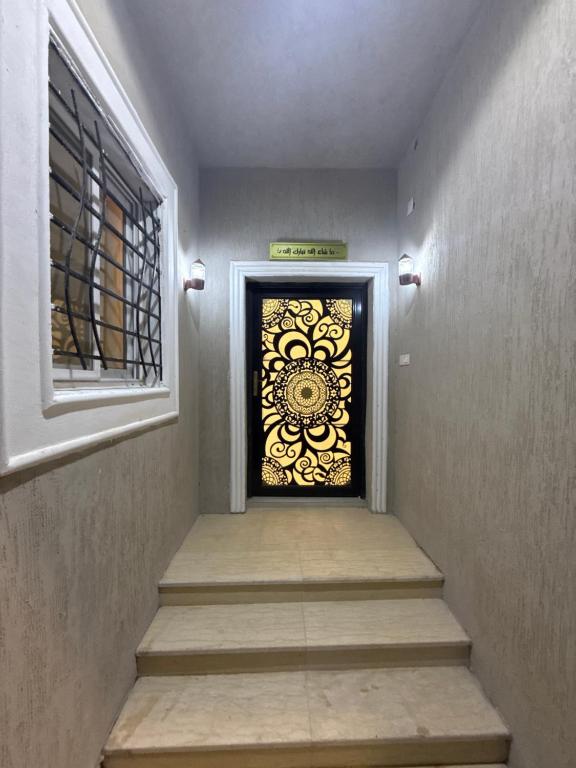 a stairway with a door with a flower design on it at غرفة نوم 3 أسرّة مدخل خاص بدون صالة in Al Baha