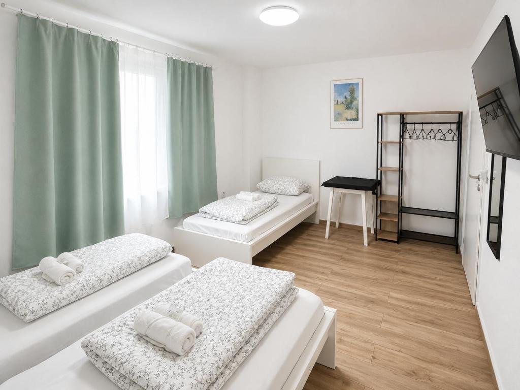 a room with three beds and a window at 92 City Rooms in Koblenz