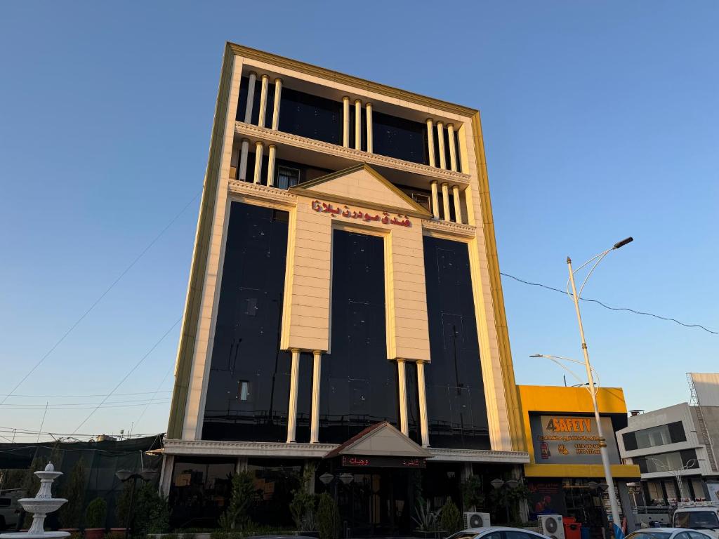 a tall building with a black and white at Modern Palace Hotel in Al Fayşalīyah