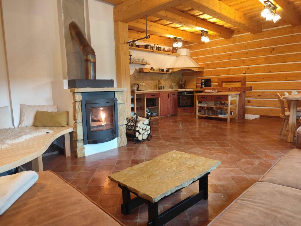 a living room with a fireplace and a stove at Roubenka Skalnička in Adršpach