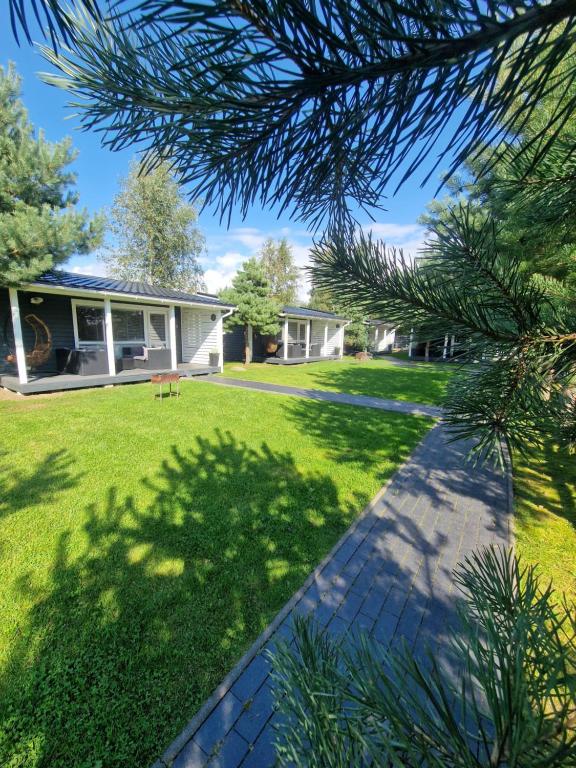 a house with a green yard with a pathway at Savas Uostas in Šventoji