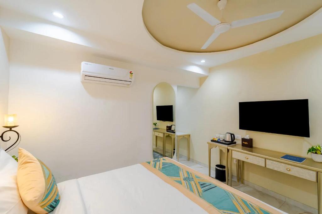 a living room with a bed and a flat screen tv at Studio by Jardin in Indore