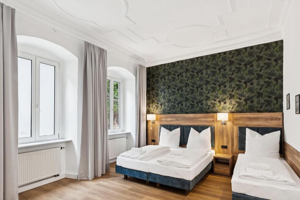 a bedroom with two beds and a green wall at Hopfenquartier Altstadt in Bamberg