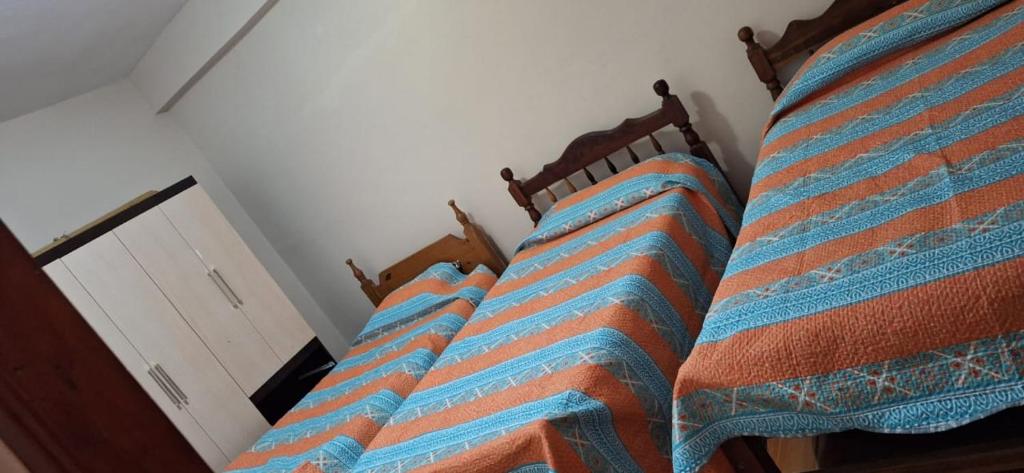 a row of four beds in a room at Ciudad de Nieva a pasos de Ciudad Cultural in San Salvador de Jujuy