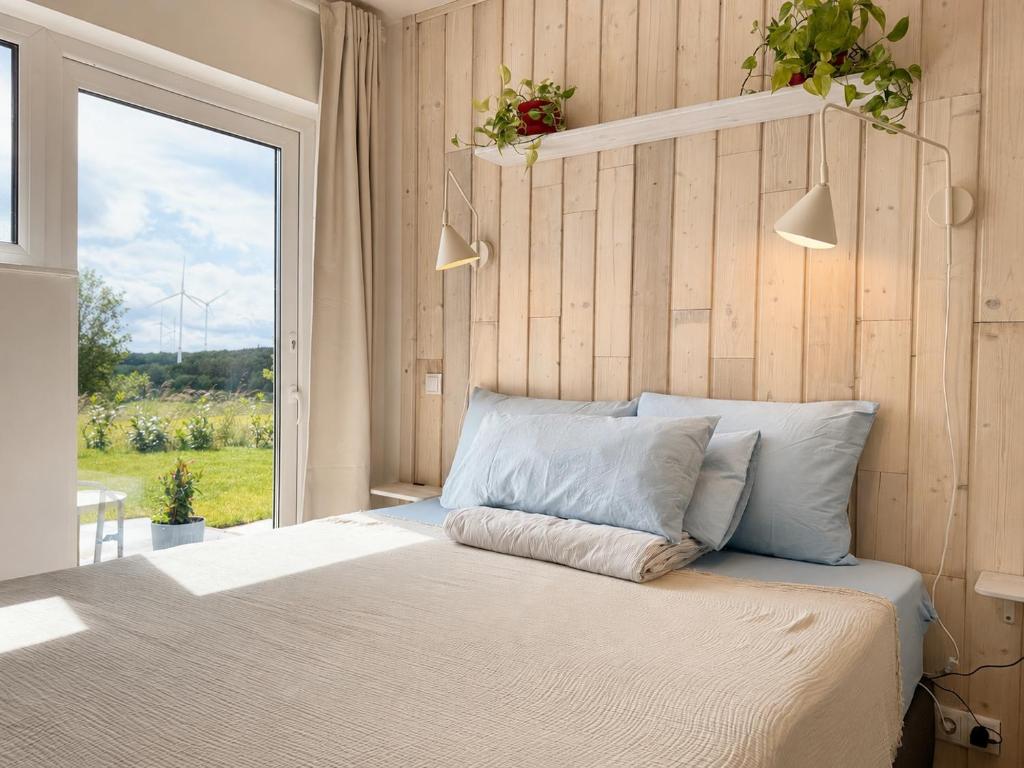 ein Schlafzimmer mit einem Bett und einem großen Fenster in der Unterkunft Homemade Studio in Liebshausen