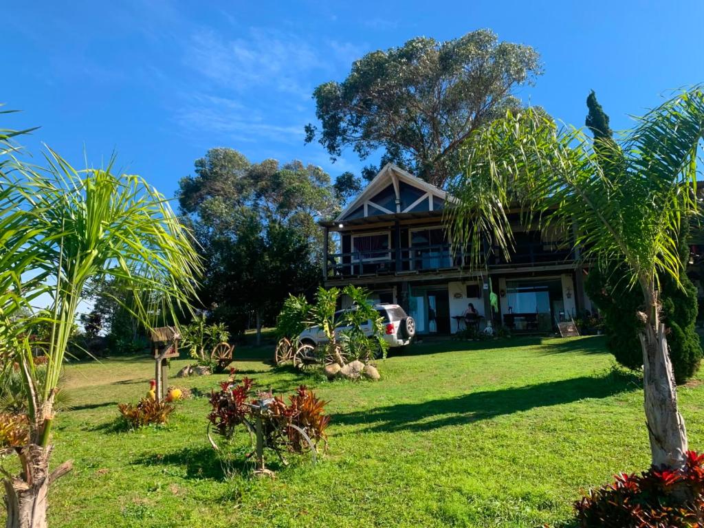 a house with palm trees in front of it at Pousada Cristais do Rosa in Imbituba