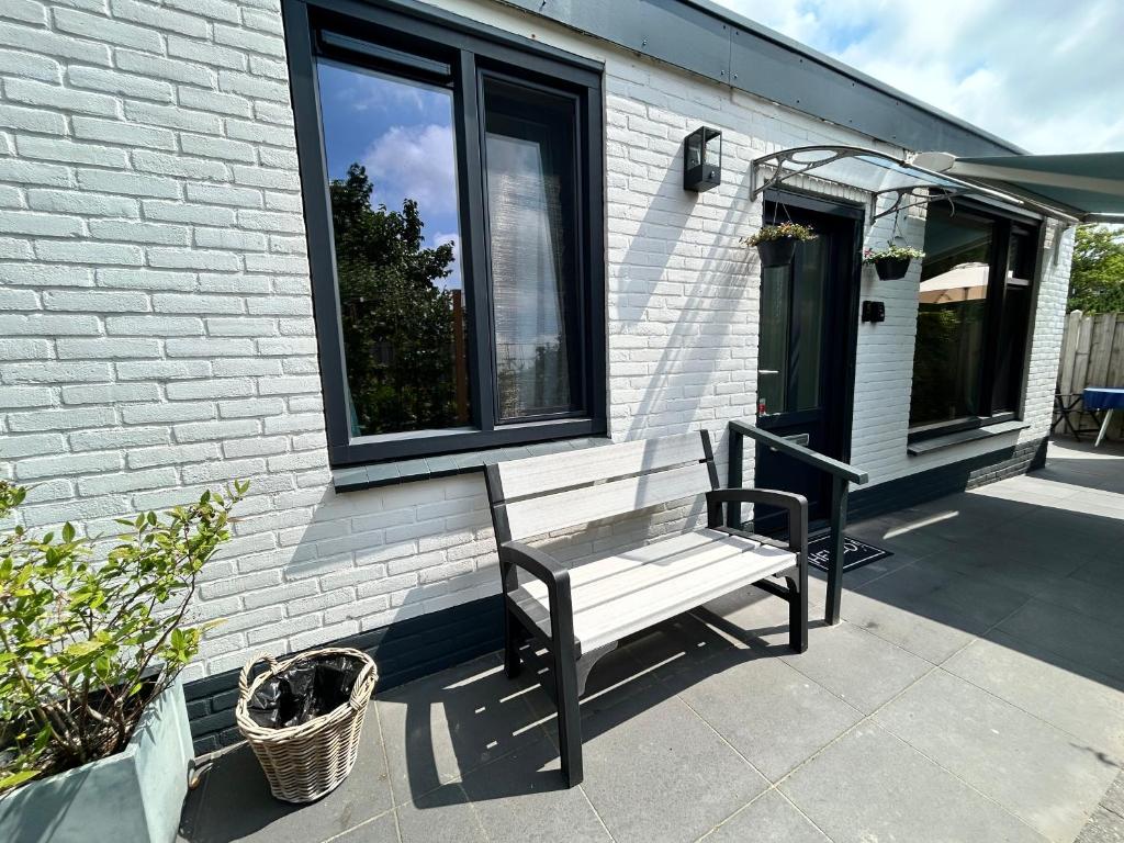 a bench sitting on the porch of a house at Vida Bonita in Den Burg