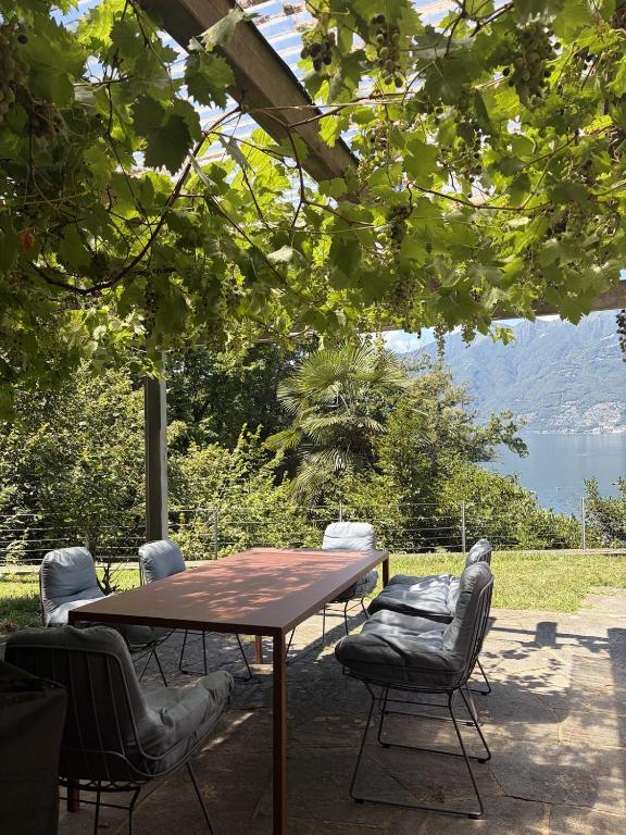 a table and chairs with a view of a lake at Ferienhaus mit Privatgarten in Gambarogno