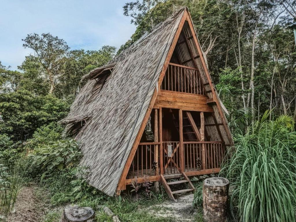 a thatch roofed house in the middle of a forest at Chalé da Mata, Ilha de Cotijuba in Belém
