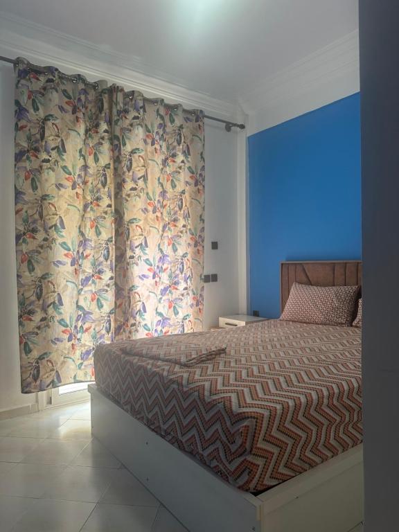a bedroom with a bed with curtains and a blue light at Stodio sofia in Essaouira