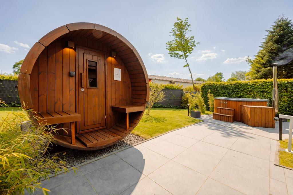 a wooden sauna in a garden with a patio at Traumfabrik Eifel mit Sauna & Whirlpool in Monschau