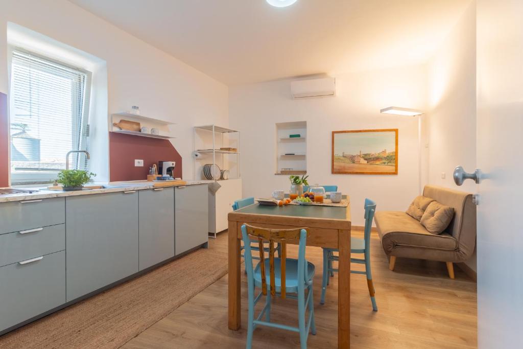 a kitchen and living room with a table and chairs at PianoPiano Nel cuore del borgo di Viterbo P1 in Viterbo
