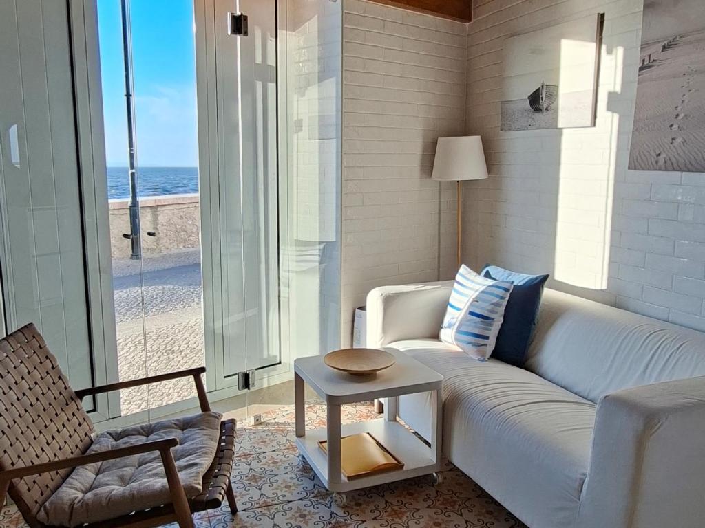 a living room with a white couch and a table at Casa do Tejo de Alcochete in Alcochete