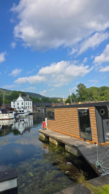 a houseboat is docked at a dock in the water at The Customs House Hotel in Bowling