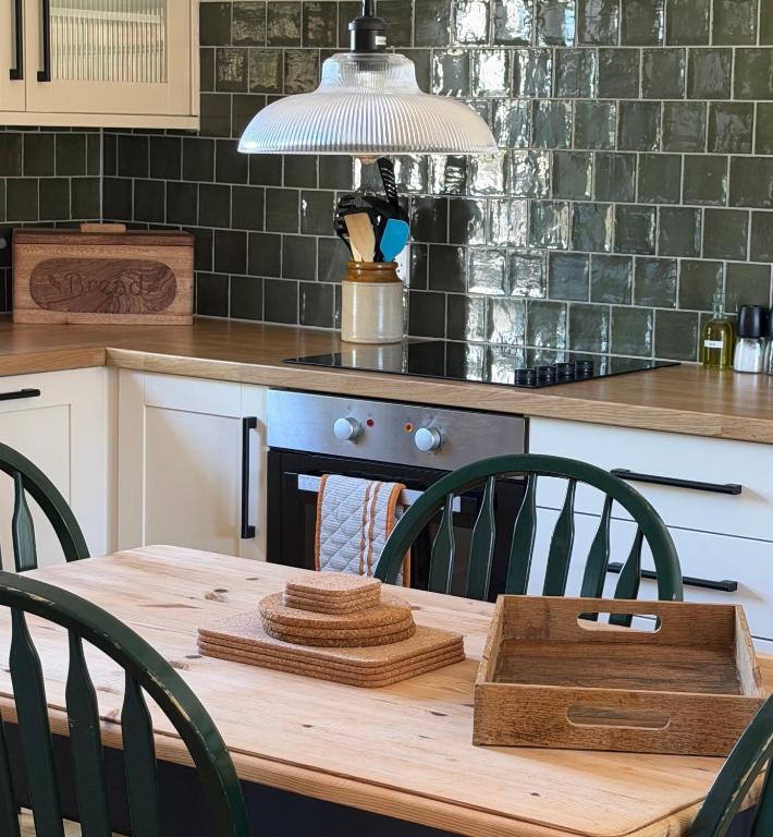 a kitchen with a wooden table with chairs and a lamp at The Old Garage in Rural Northumberland in Edlingham