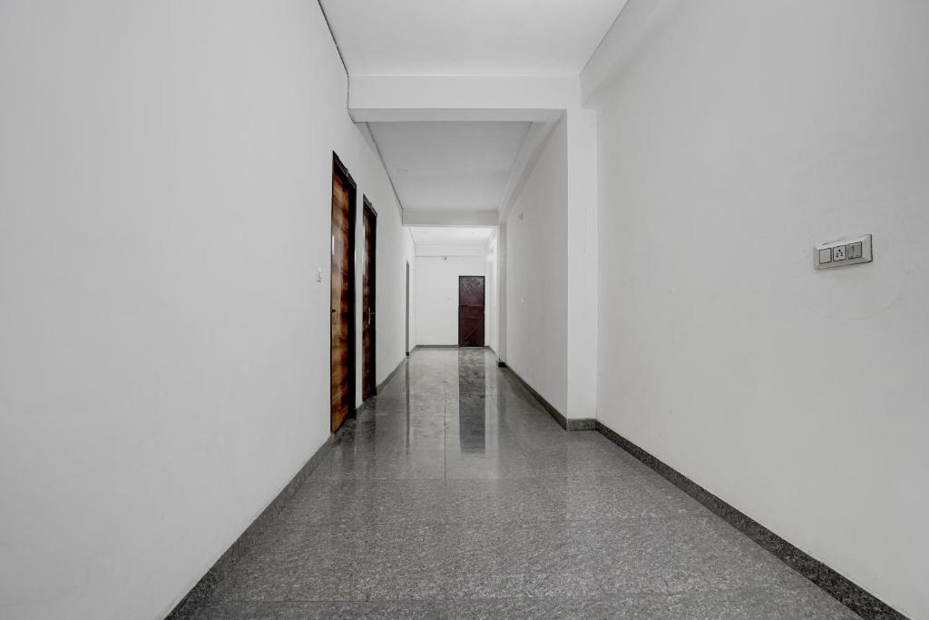 an empty hallway with white walls and tile floors at SPOT ON VS in Delhi