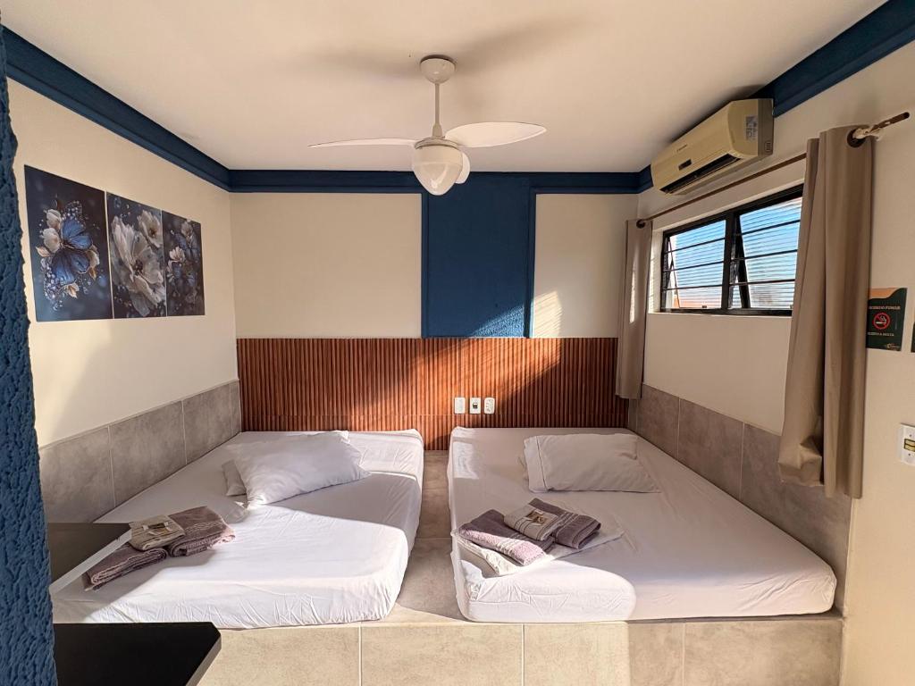 two beds in a room with blue walls at Pousada Caminhos do Interior in Sorocaba