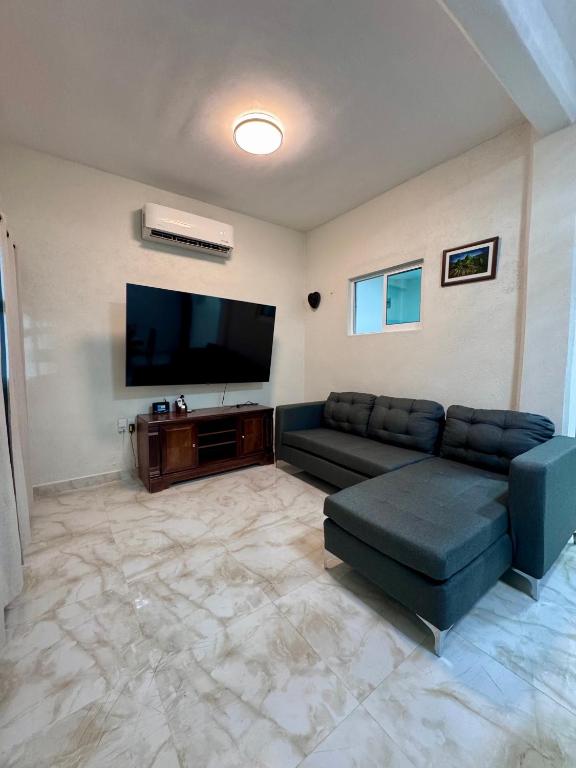 a living room with a couch and a flat screen tv at Casa Chu in Acapulco