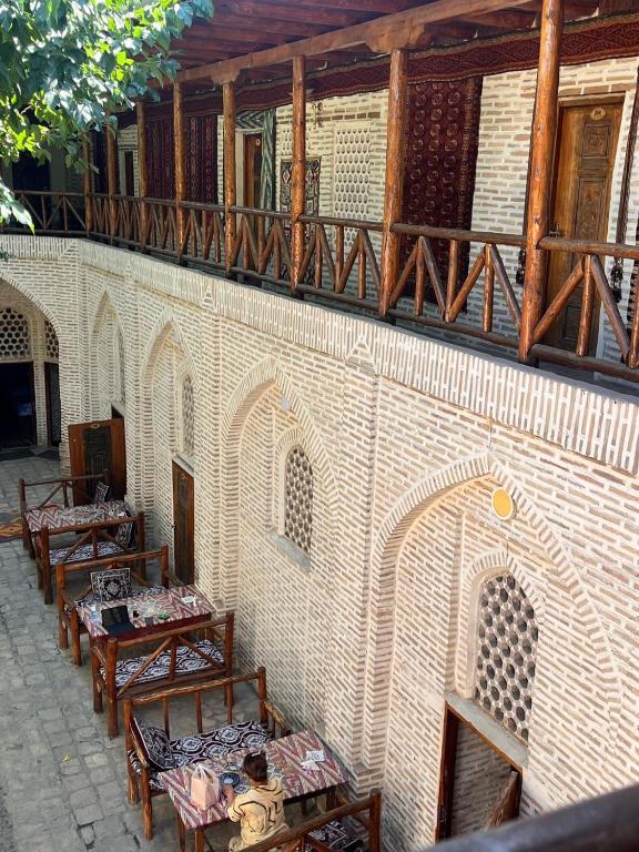 a group of tables and benches in a building at Sarbon Boutique Hotel in Bukhara