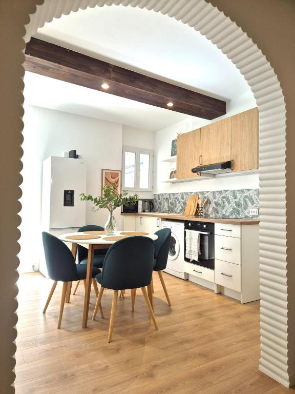 a white kitchen with a table and chairs at Maison des Arches in Barbentane