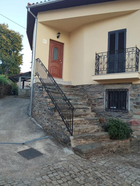 a house with a red door and stairs at Casa Ramos in Mogadouro