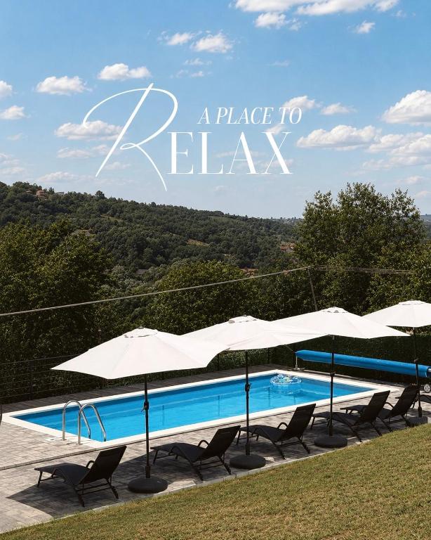 a swimming pool with chairs and umbrellas next to it at Villa Jaram Private Pool & BBQ Escape in Jarmenovci