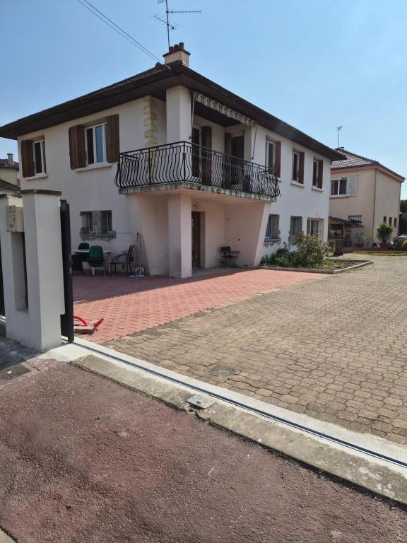 a white house with a balcony and a brick driveway at Maison de Luxe 2 in Chalon-sur-Saône